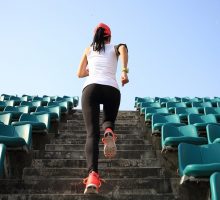 Woman running up a set of stadium stairs for exercise