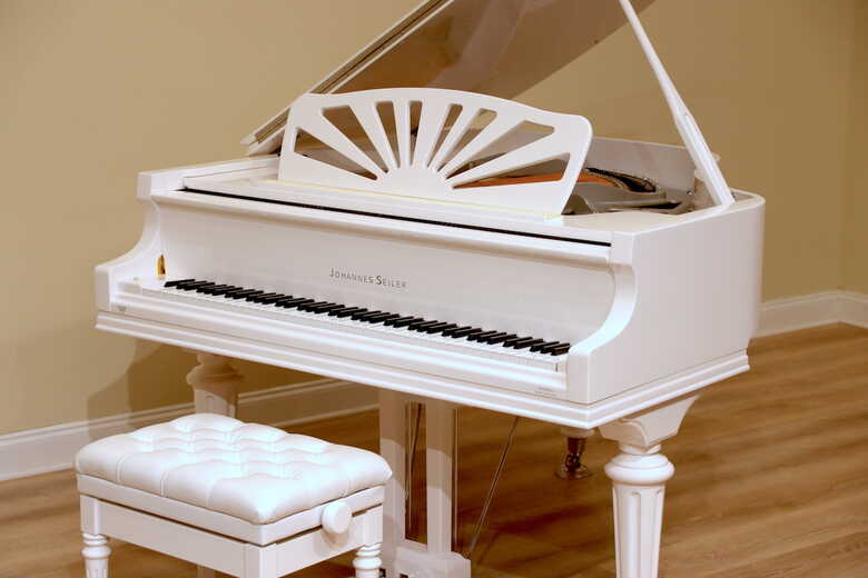 Nearly new white baby grand with silver trim