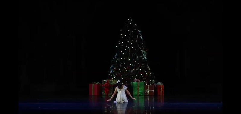 Clara kneeling in front of Christmas Tree