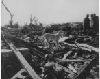 Men_and_dog_inspect_rubble_left_by_tornado._Udall__Kansas_-_NARA_-_283889.jpg