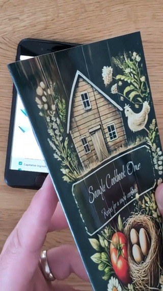 Saddle-stitch cookbook showing its thin folded spine and flexible cover