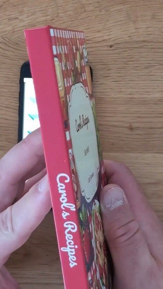 Hardcover cookbook showing its red printed spine and rigid cover