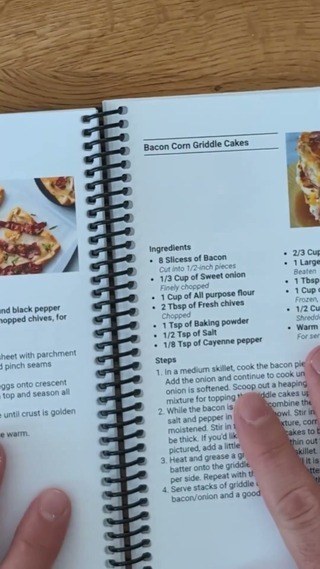 Open coil-bound cookbook showing its spiral binding and recipe pages