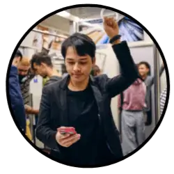 A screenwriter capturing an idea through his phone while standing on the subway. Maybe it's a character note or outline beat. Either way, he's able to get it down on the go.