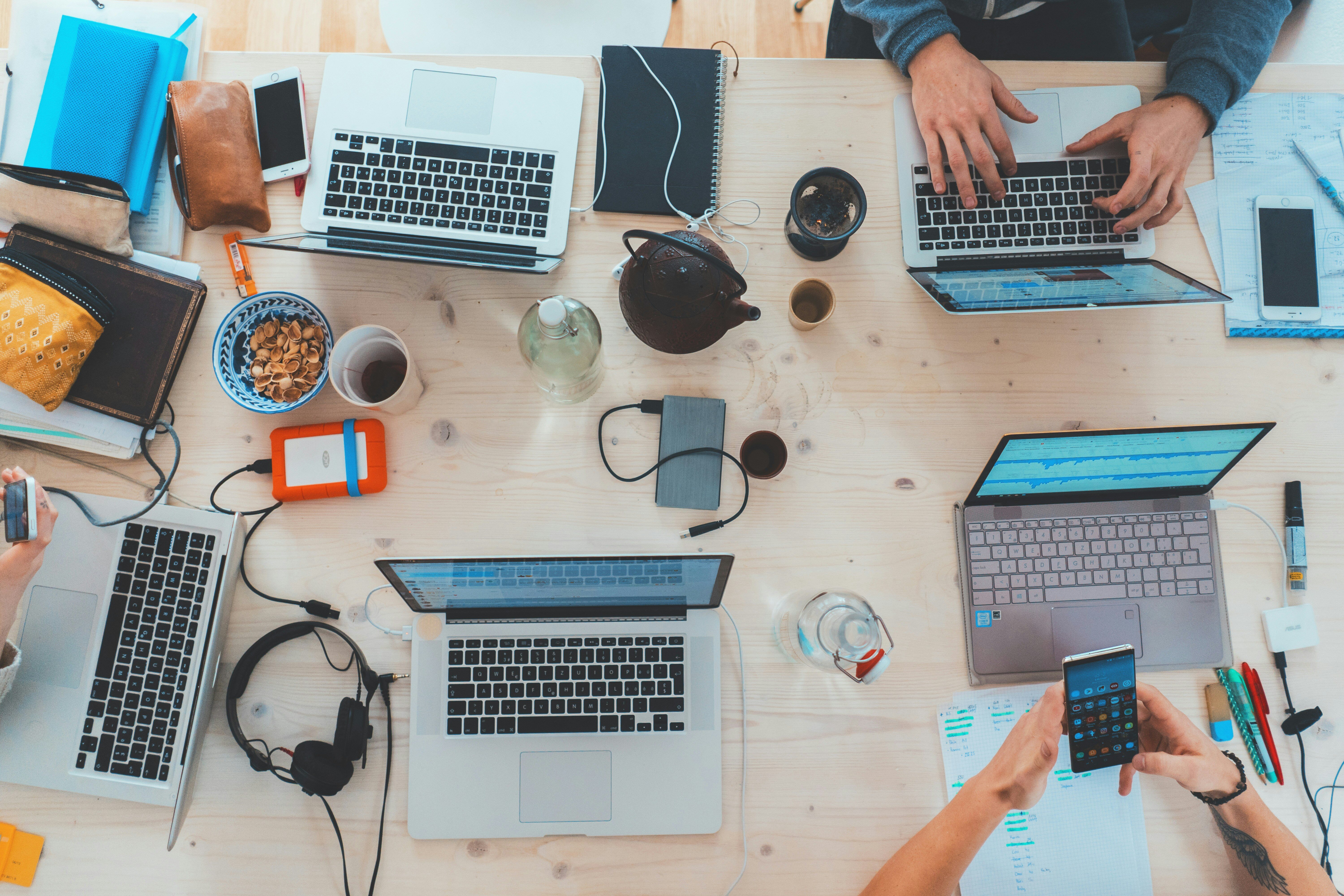 aerial view of a group of laptops sitting open on a table 