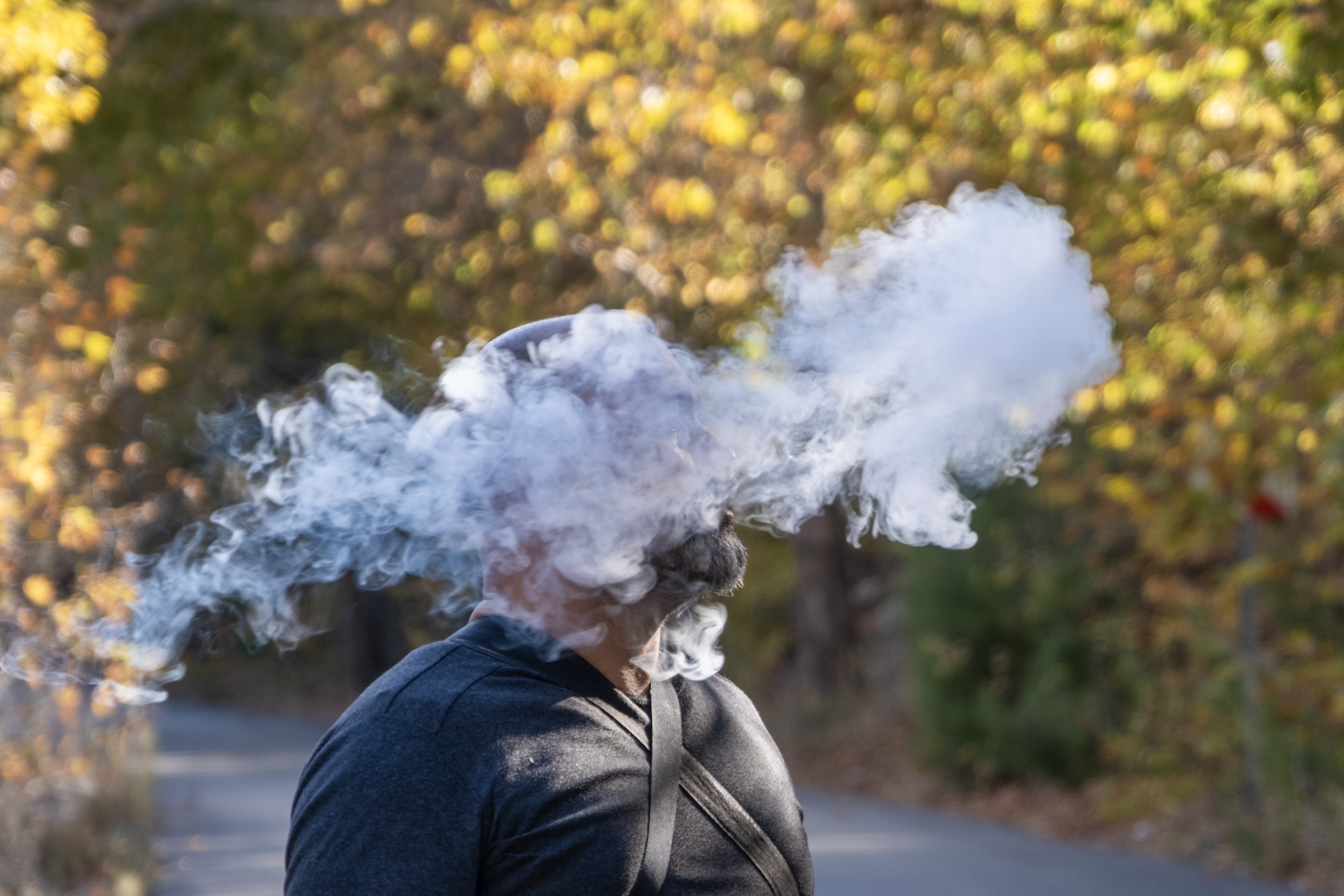 A man smoking a cigarette in autumn