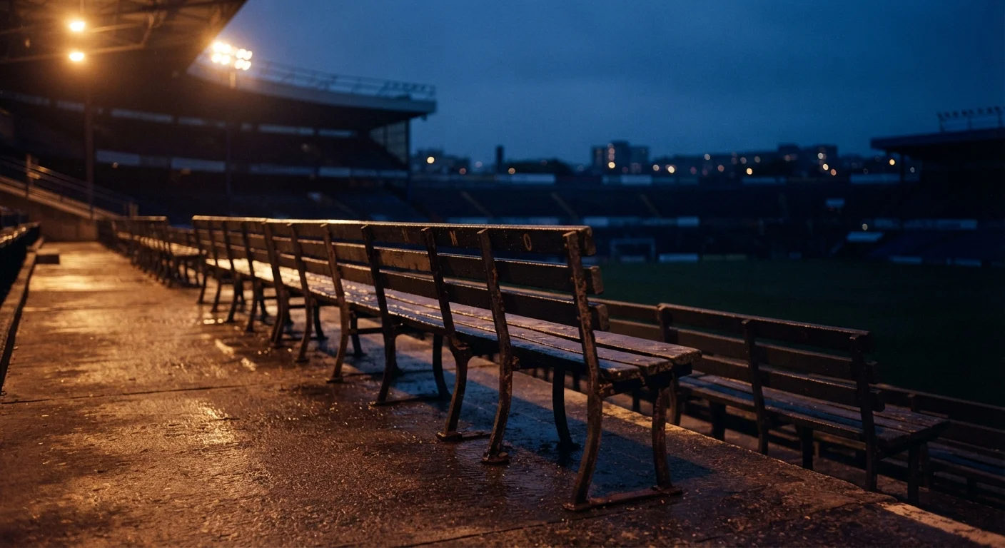 Floodlit empty seats under stadium lights at dusk