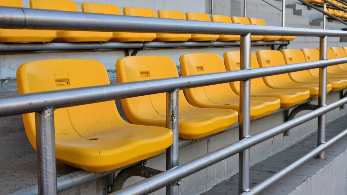 Close-up of yellow rail seat barriers in a stadium