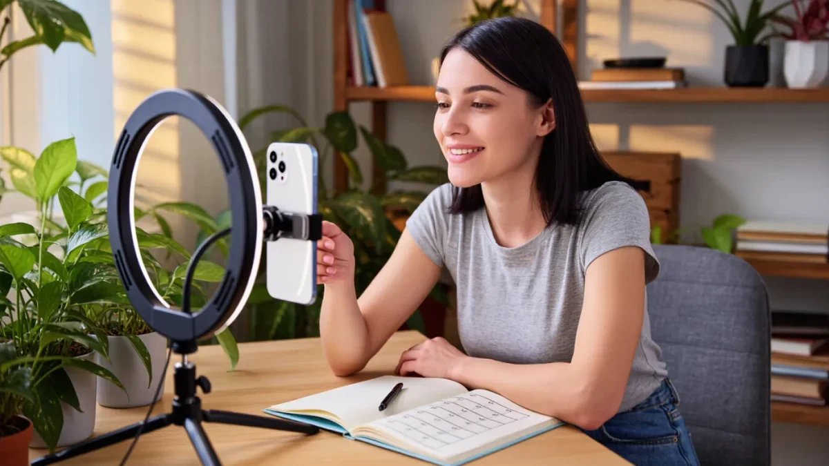 Creator filming a video with ring light and phone camera at home