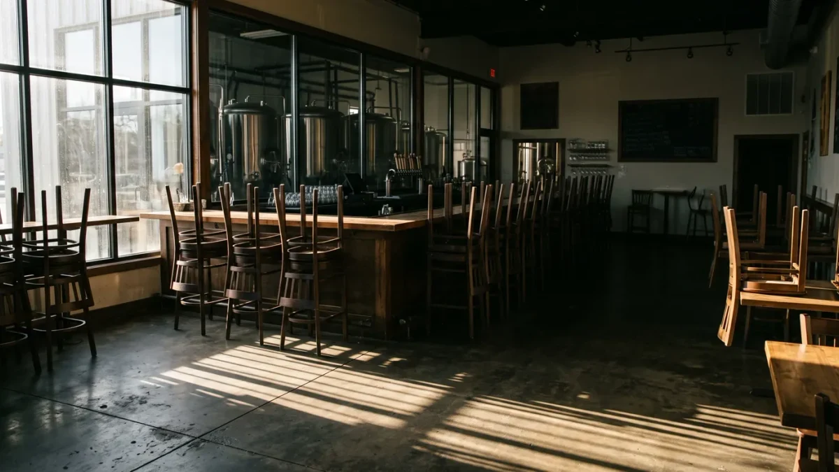 Empty bar stools in a closed taproom with stacked chairs
