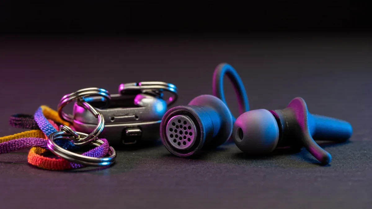 Close-up of high-fidelity earplugs with filter stems on dark surface