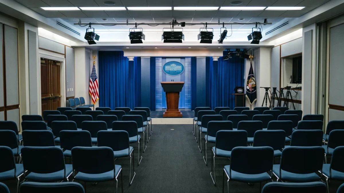 Empty press briefing room podium with rows of chairs