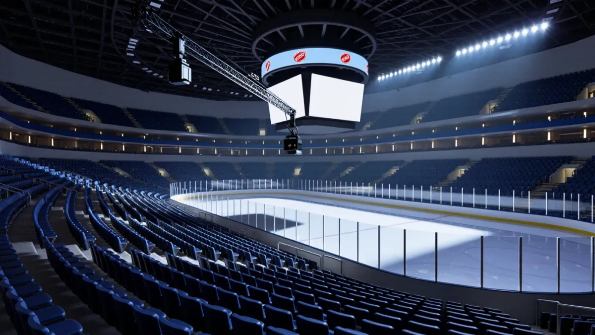 Empty hockey arena seats beneath broadcast cameras before a game