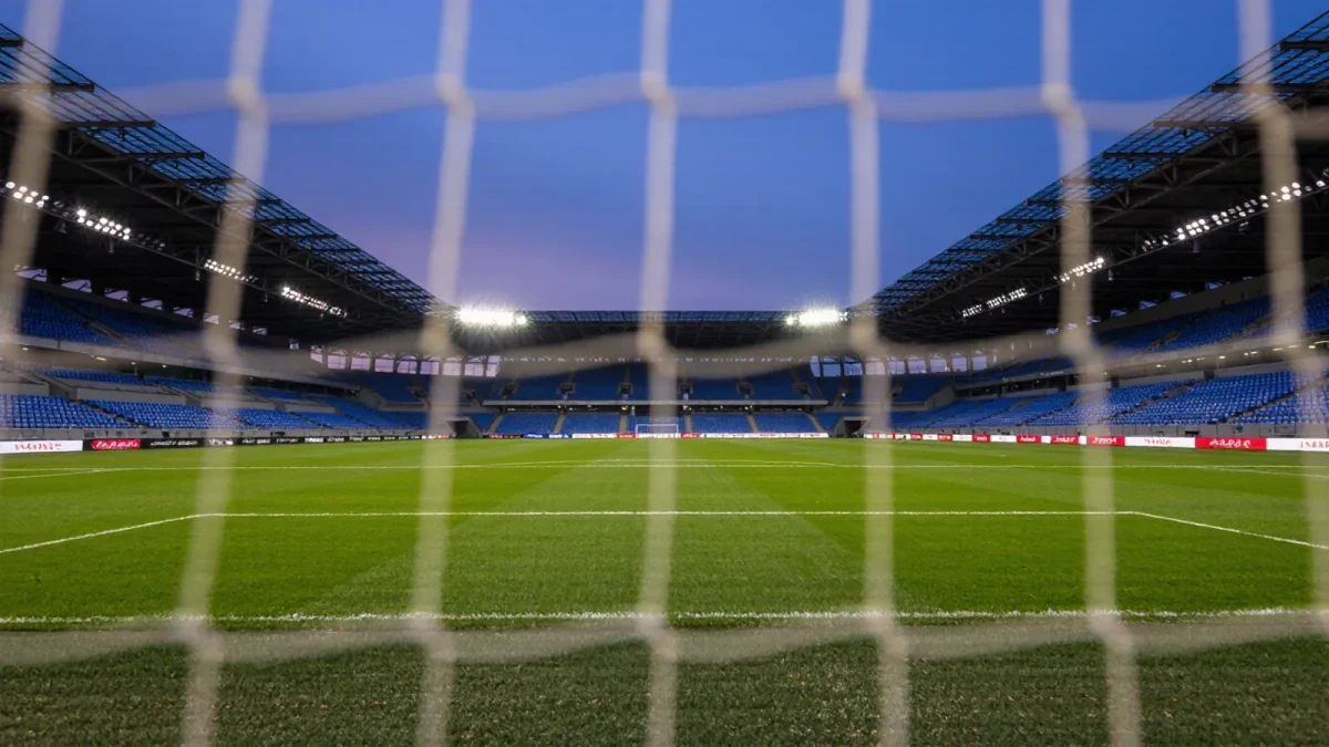 Empty stadium goal net at dusk with pitch markings