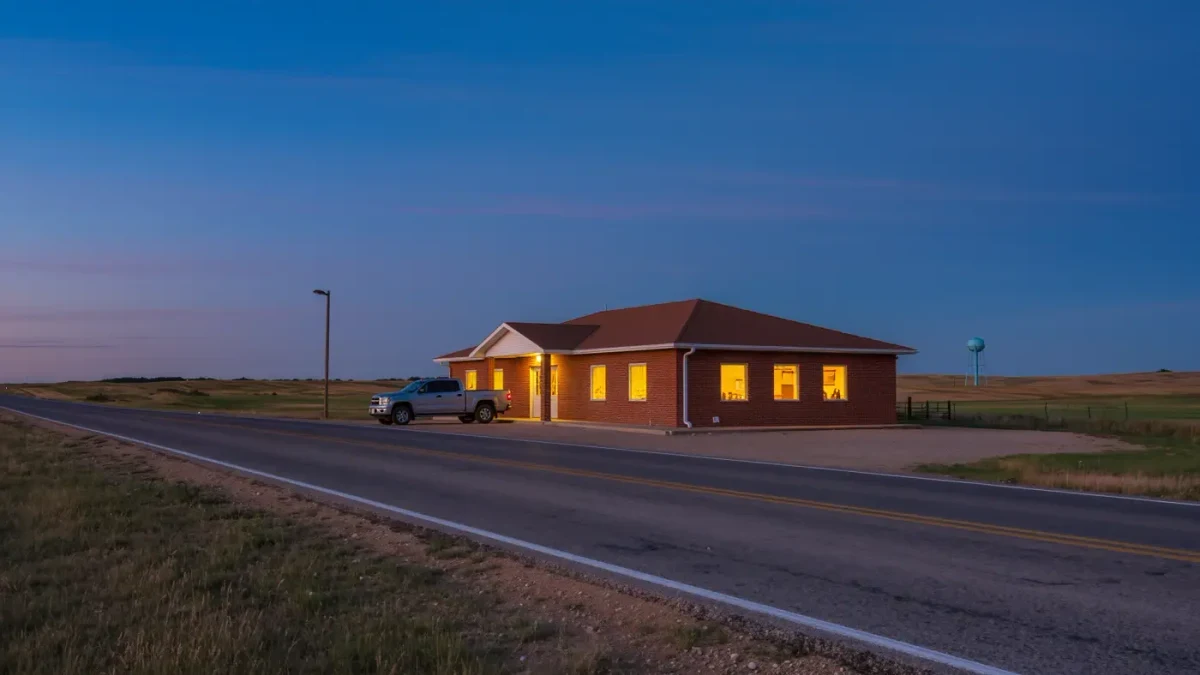 Small-town library at dusk with warm lit windows