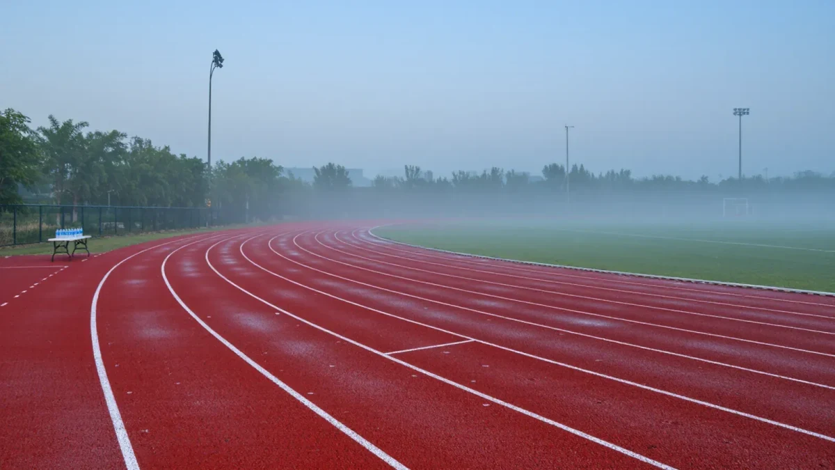 Empty athletics track section with hydration station at dawn