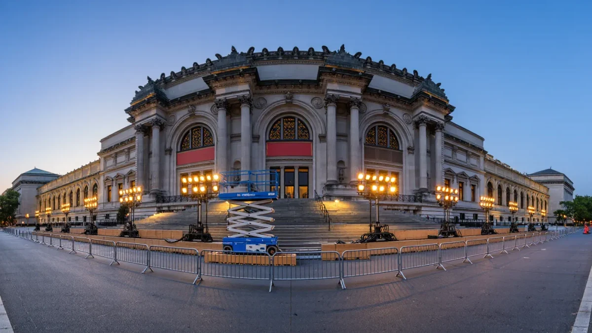 Museum facade at dawn with lighting rigs and empty barricades