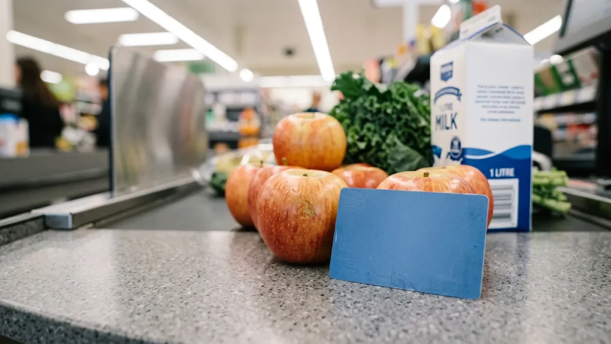 Shelf of grocery produce and an EBT card on a checkout counter