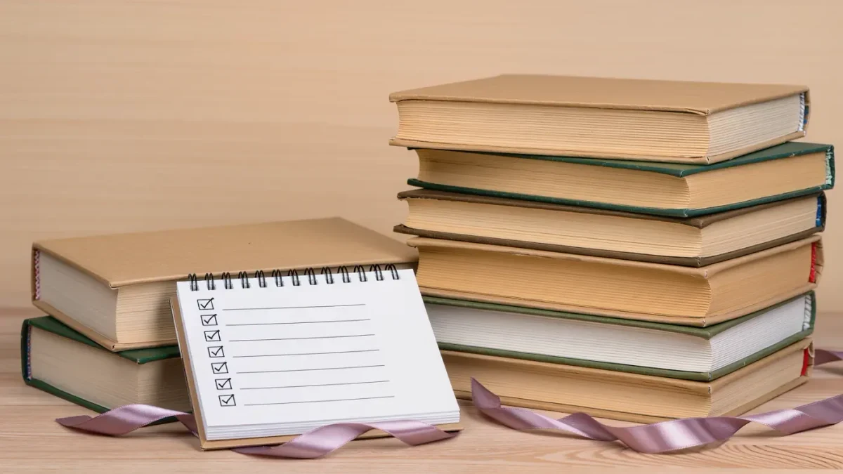 Close-up of a towering stack of submission novels and a reading log