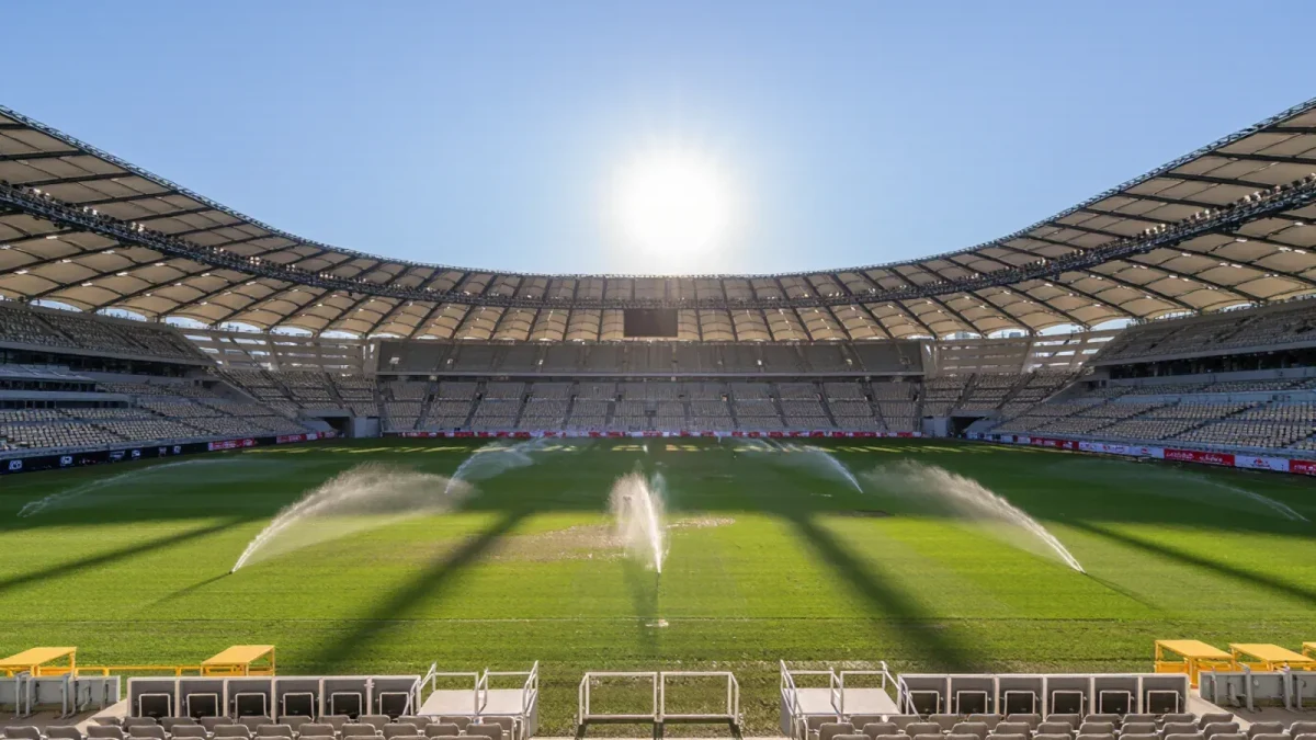 Sun-baked stadium pitch shimmering at midday heat