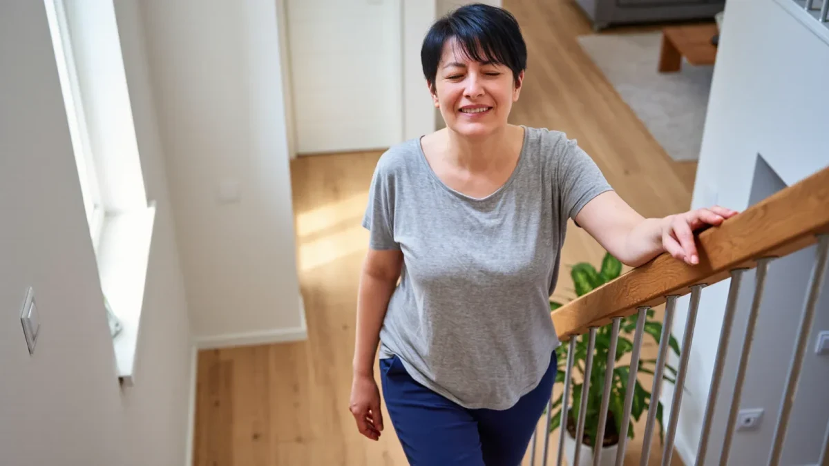 Middle-aged runner walking stiffly down stairs two days after a race