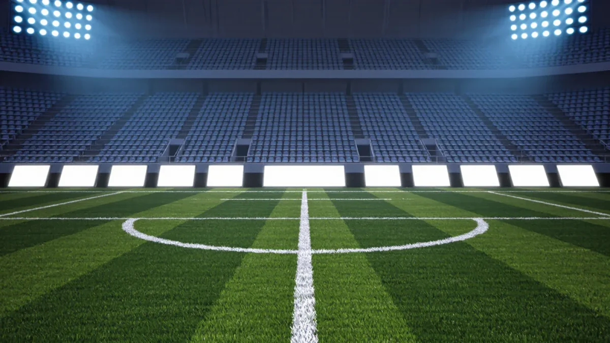 Empty stadium advertising boards under bright floodlights