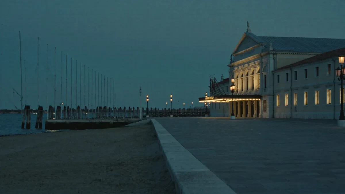 Venice Lido waterfront cinema palace at dusk, empty promenade