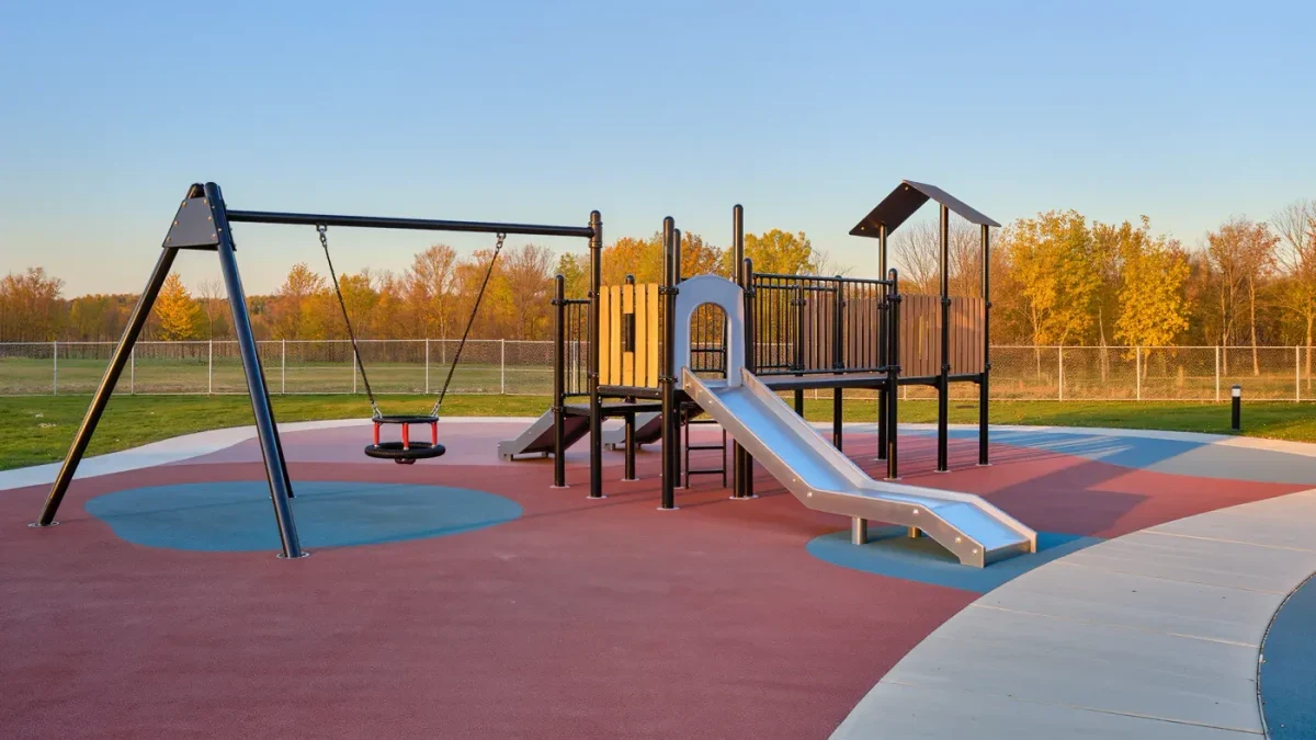 Empty inclusive playground with rubber surfacing and ramped play structure