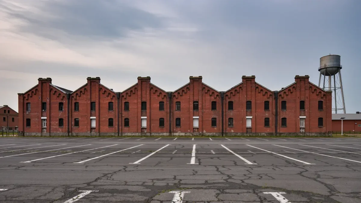 Closed brick textile mill with empty parking lot in small town