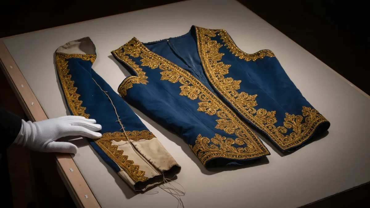 Close view of a richly embroidered vintage theatre costume under conservation studio light