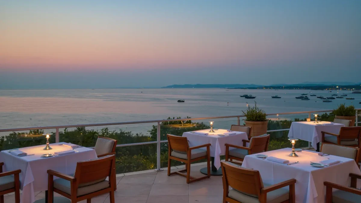 Empty evening terrace by the waterfront with white tablecloths, silver candles and dusty blue dusk light