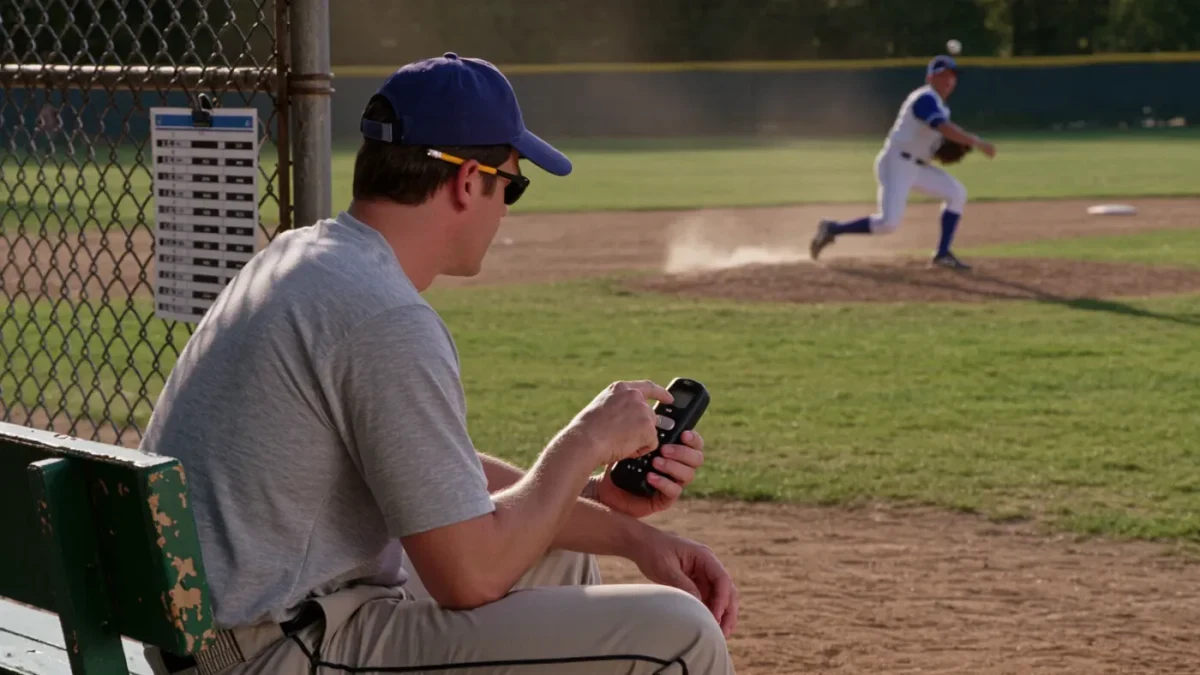Youth baseball coach logging pitches during a game
