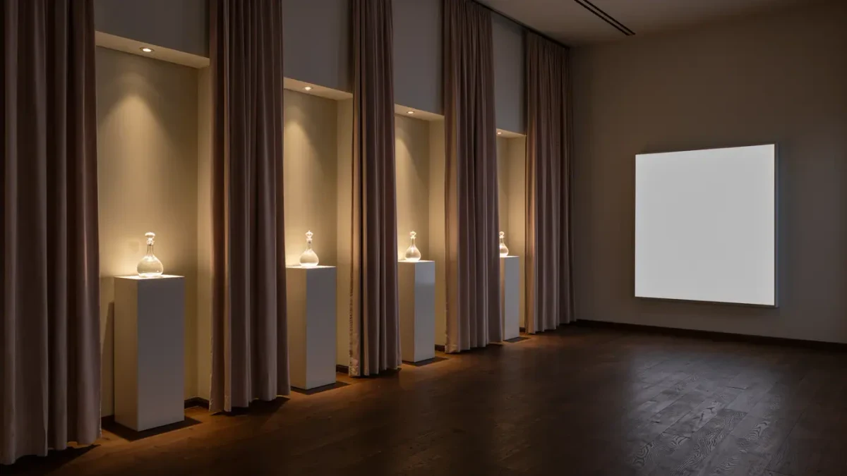 Empty immersive launch salon with curtained archways and lit plinths