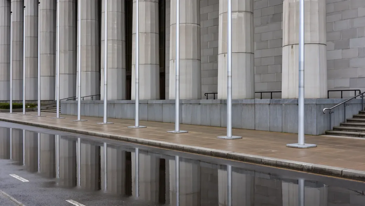 State capitol colonnade in flat morning light with bare flagpoles