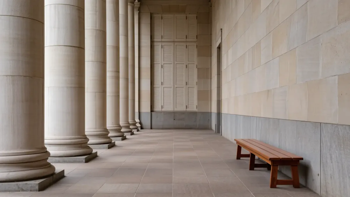 Courthouse corridor with marble columns and bench seating under soft window light