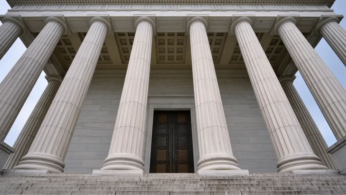 Marble colonnade and bronze doors of a courthouse entrance under overcast light