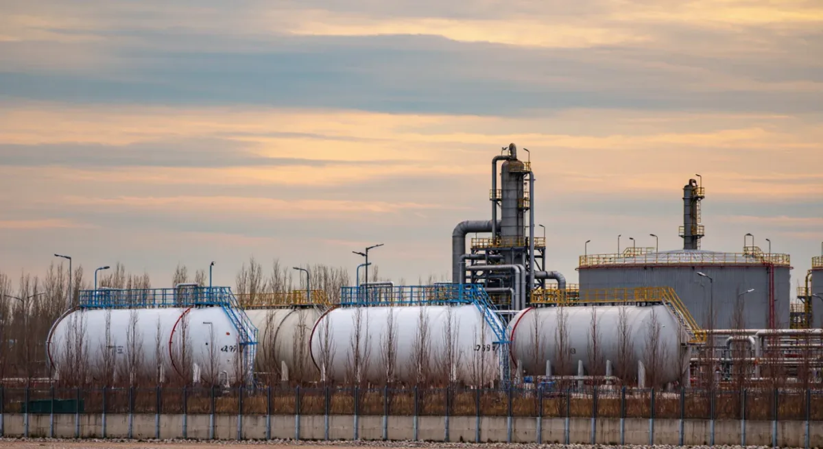 Insulated industrial storage tanks under an autumn sky