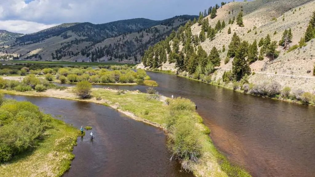 BGrossenbacher-0059 - Western Ranch Brokers Winding river with fly fisherman alongside mountains on a Montana ranch for sale