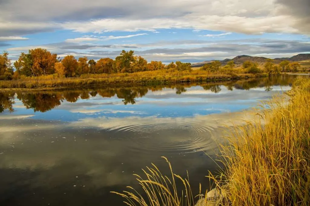 BGrossenbacher-0509 - Western Ranch Brokers Water reservoir reflecting cloudy sky on a Montana ranch
