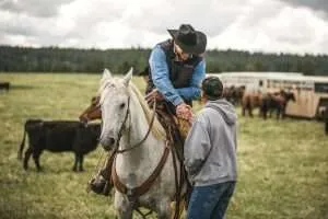 5E1A0995 - Western Ranch Brokers Ranch Broker Bill Boyce on horseback shaking hands with a man