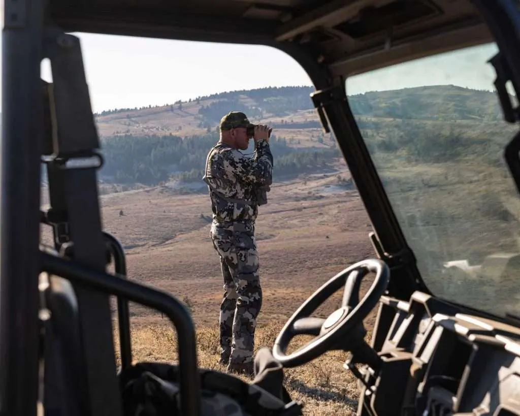 Ranch broker Bill Boyce looking through binoculars on a hunt