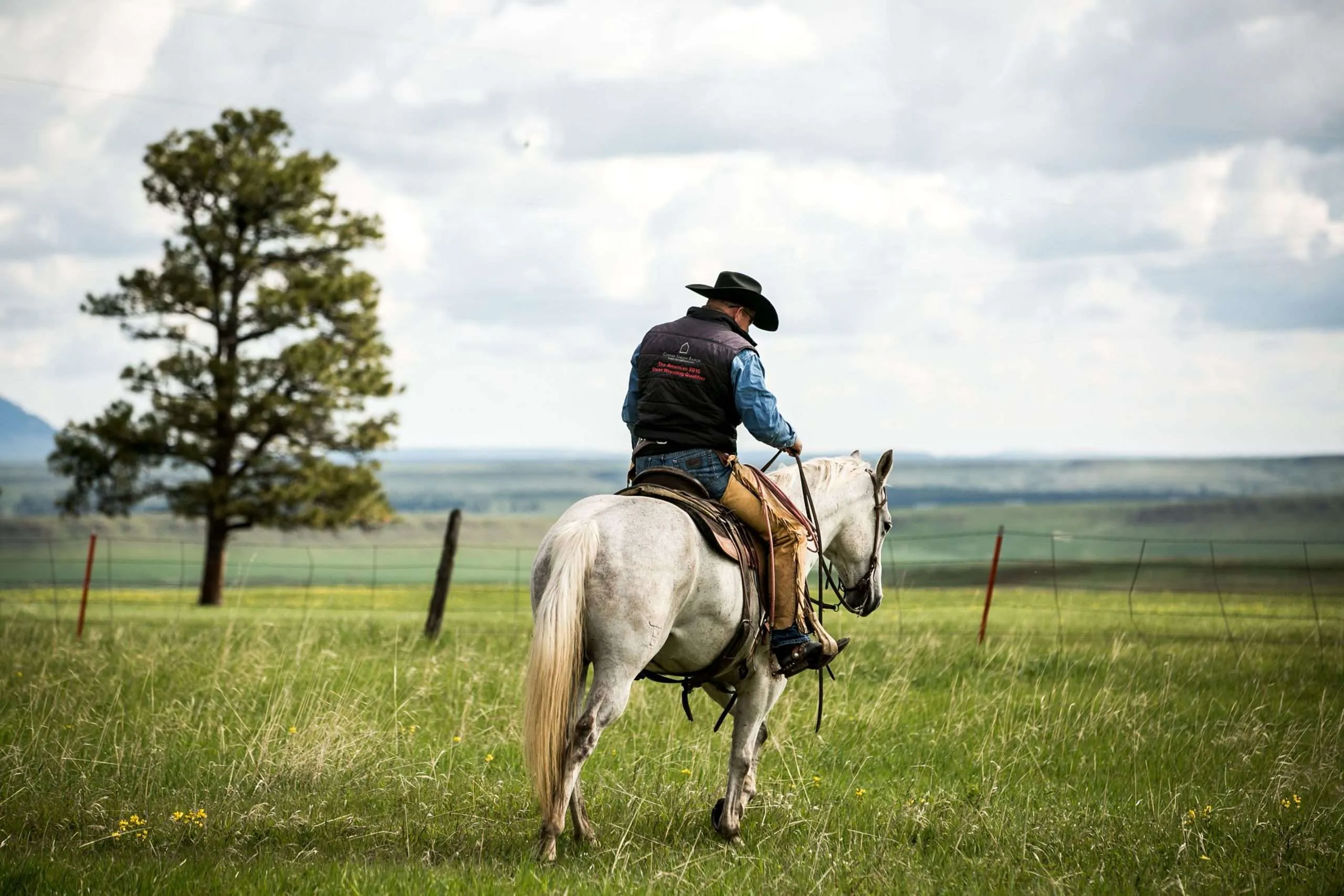 Ranch broker Bill Boyce riding a white horse