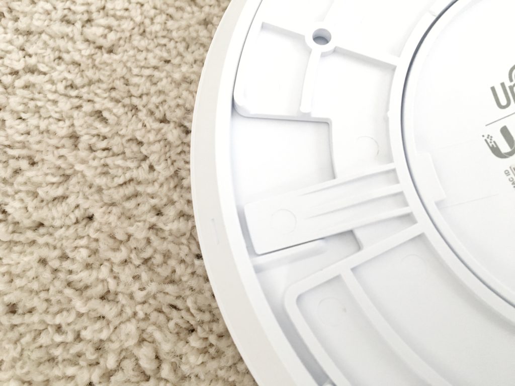 Close-up of the back of a UniFi access point showing the mounting ring's locking tab