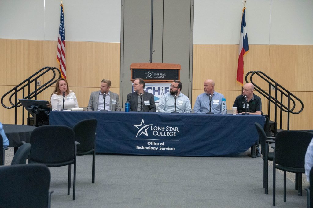 Six expert panelists seated at the Lone Star College table in front of U.S. and Texas flags